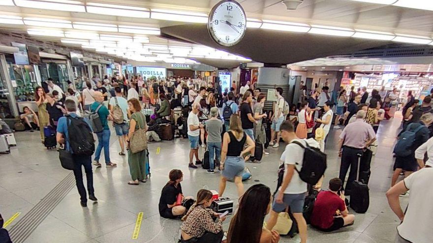 Viajeros esperan la reanudación ferroviaria en la estación de Atocha.