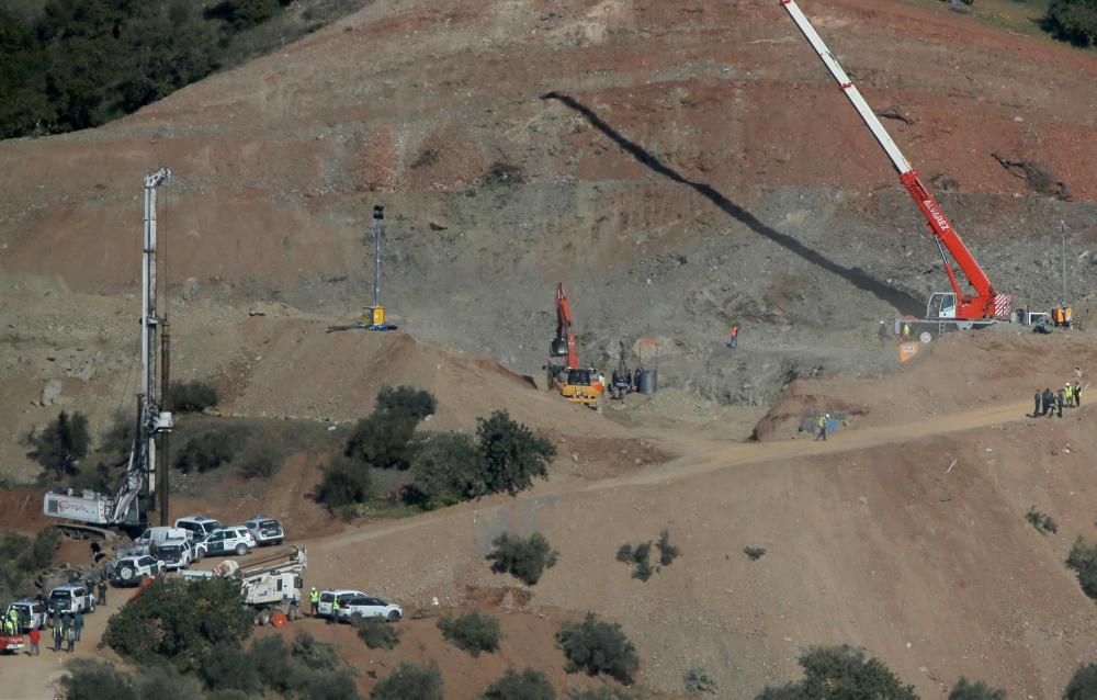 Members of a miner rescue team watch a drilled ...