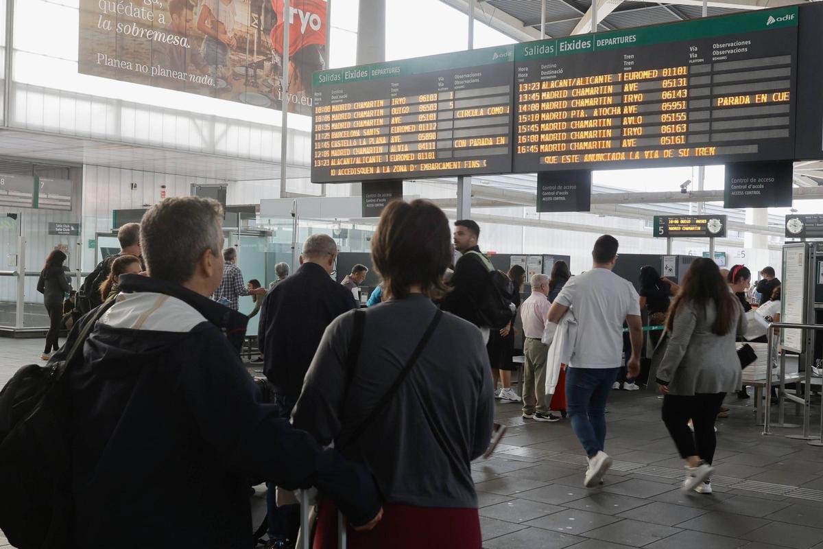 Los pasajeros del AVE miran el panel con la información de los trenes.