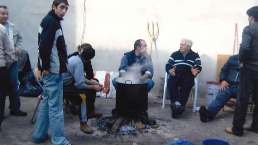 Un grupo de hombres frente a un recipiente en plena cocción.