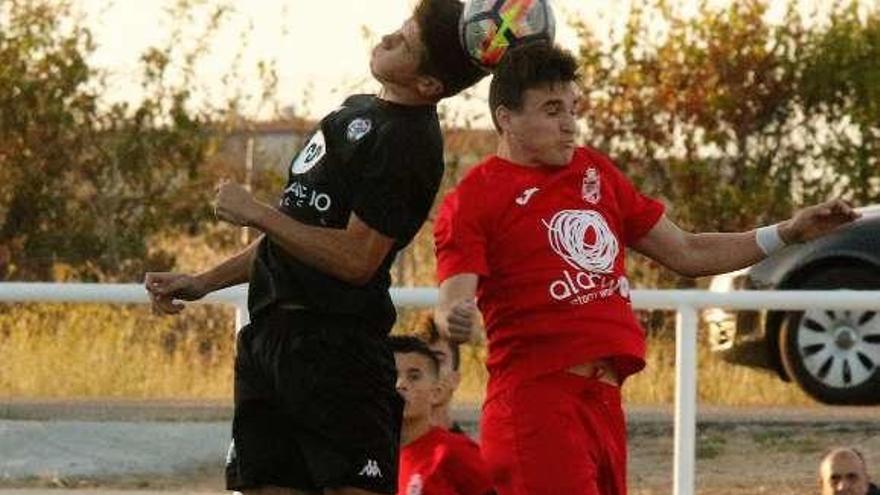 Disputa de balón aéreo en un encuentro de los juveniles