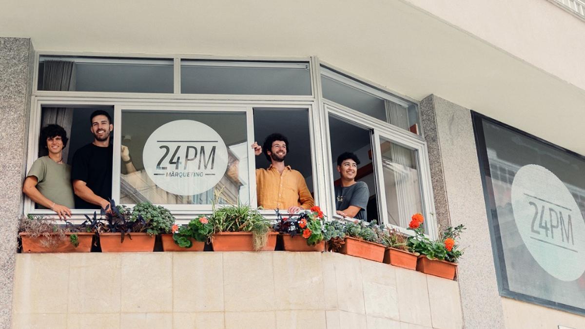 Los componentes de 24PM, en la ventana del local que tienen en la plaza de Sa Bassa de Manacor.