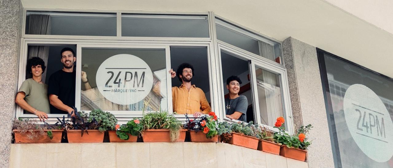 Los componentes de 24PM, en la ventana del local que tienen en la plaza de Sa Bassa de Manacor.