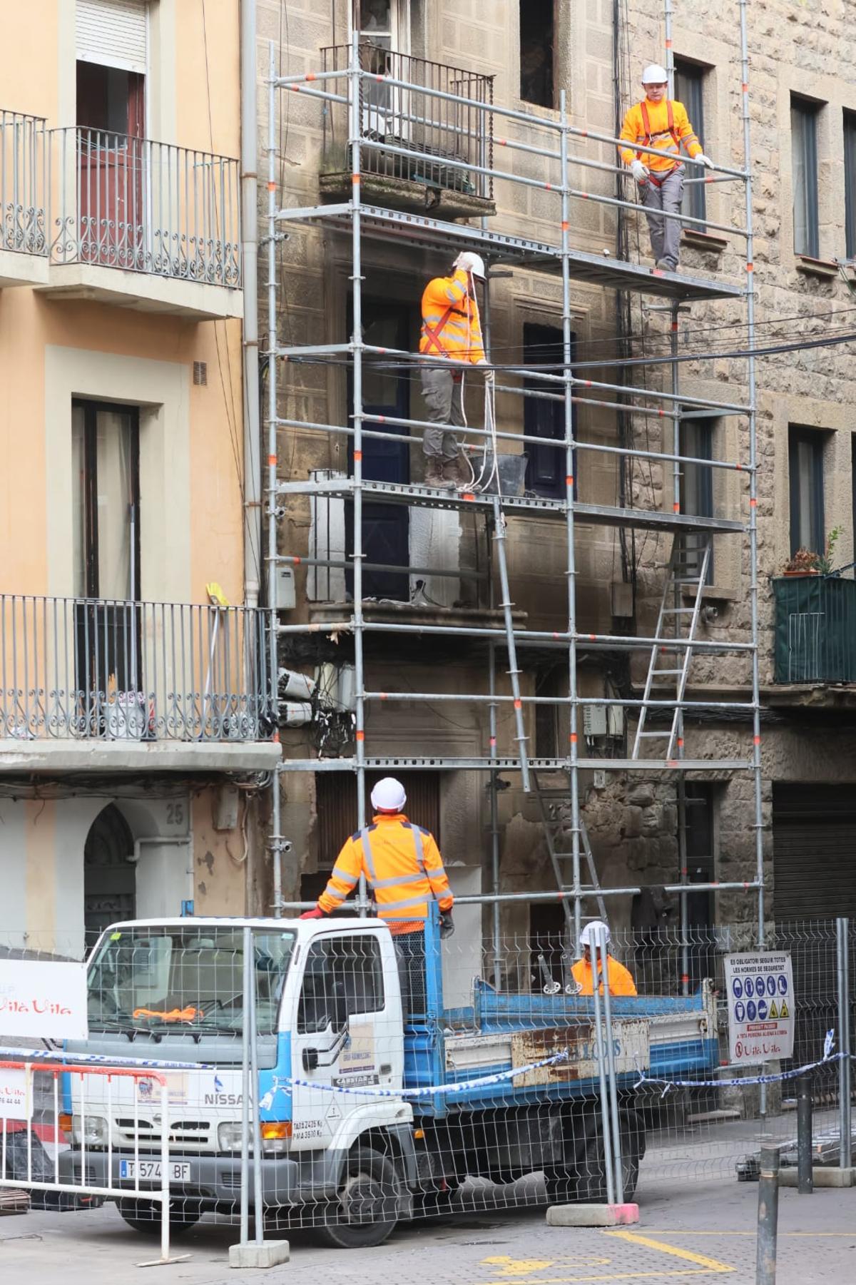 Operaris enfilats ja a la bastida al número 27 del carrer de Santa Llúcia per a procedir a l'enderroc