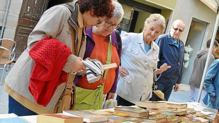 Observant llibres per intercanviar en una parada a Berga, ahir