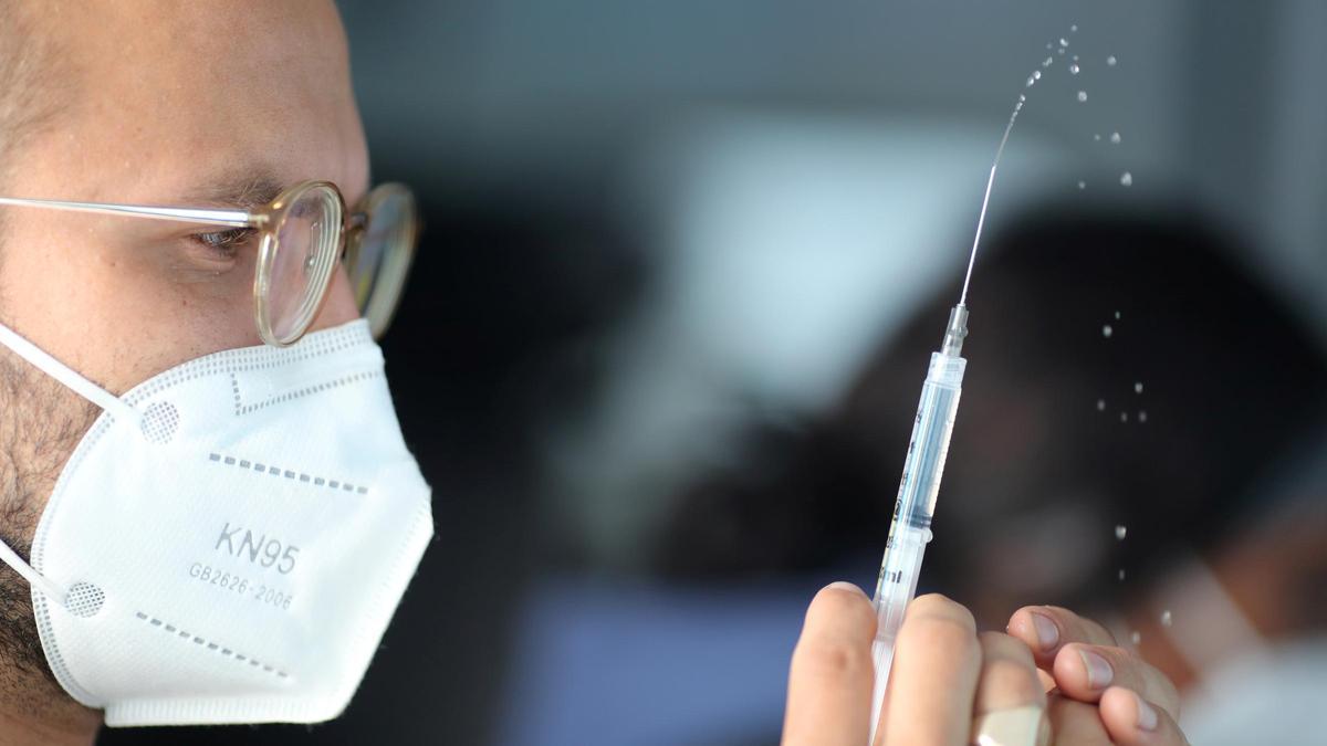 Un sanitario prepara un vial con una de las vacunas contra el coronavirus