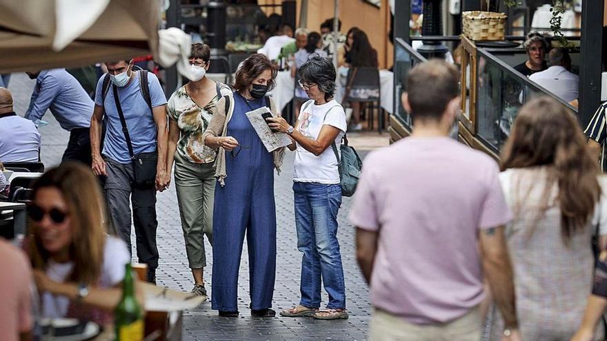 En el centro de la imagen, dos turistas mirando un plano en la calle Gascona, en Oviedo. | IRMA COLLÍN