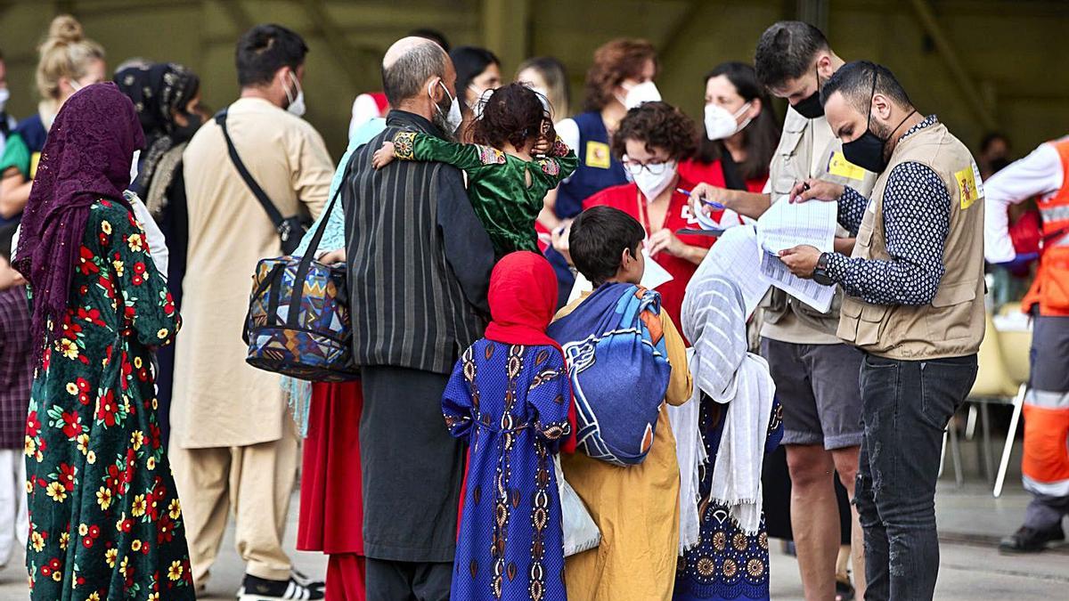 Una familia de refugiados afganos presenta la documentación pertinente al personal de la base de Torrejón de Ardoz. | JESÚS HELLÍN / EUROPA PRESS