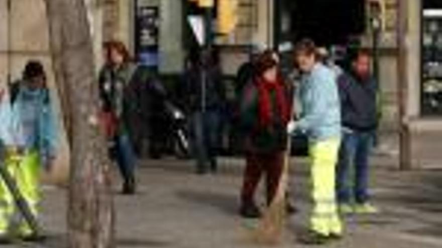 Dues escombriaires a peu netejant un carrer, en una imatge d&#039;arxiu.