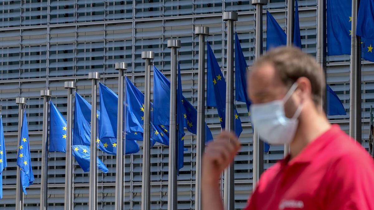 Un hombre con mascarilla, ante la sede de la Comisión Europea, en Bruselas.