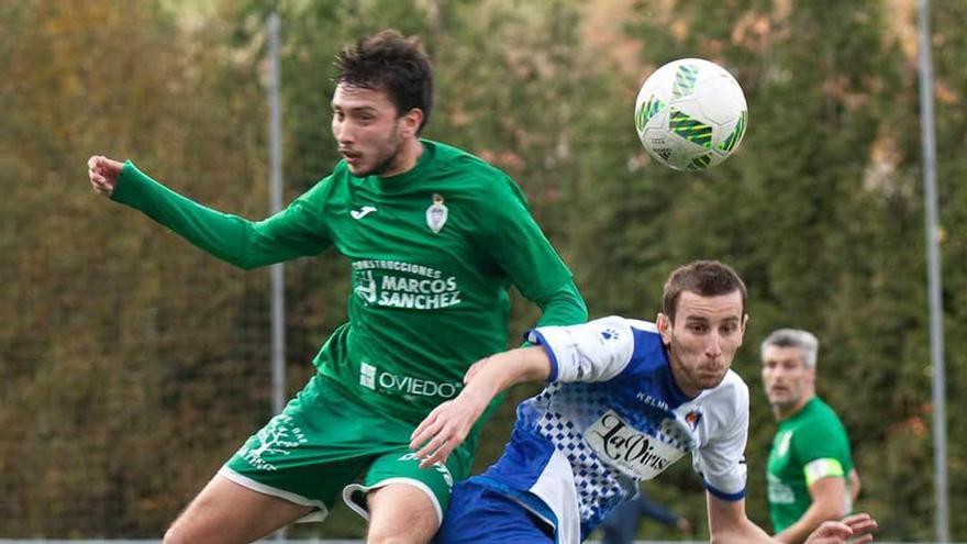 Ángel y Chema disputan un balón en el Tuilla-Covadonga.