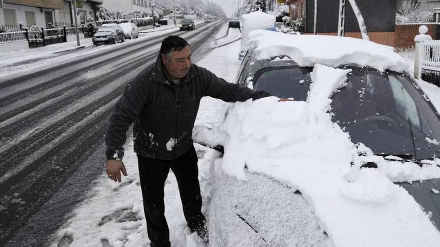 Un hombre retira la nieve de su coche en Lalín.