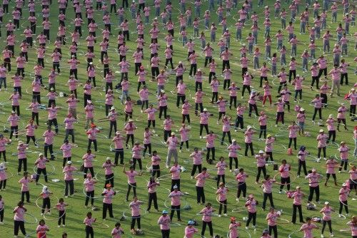 Gente tomando parte en un intento de superar el record mundial de hula hoops en las afueras de Bangok