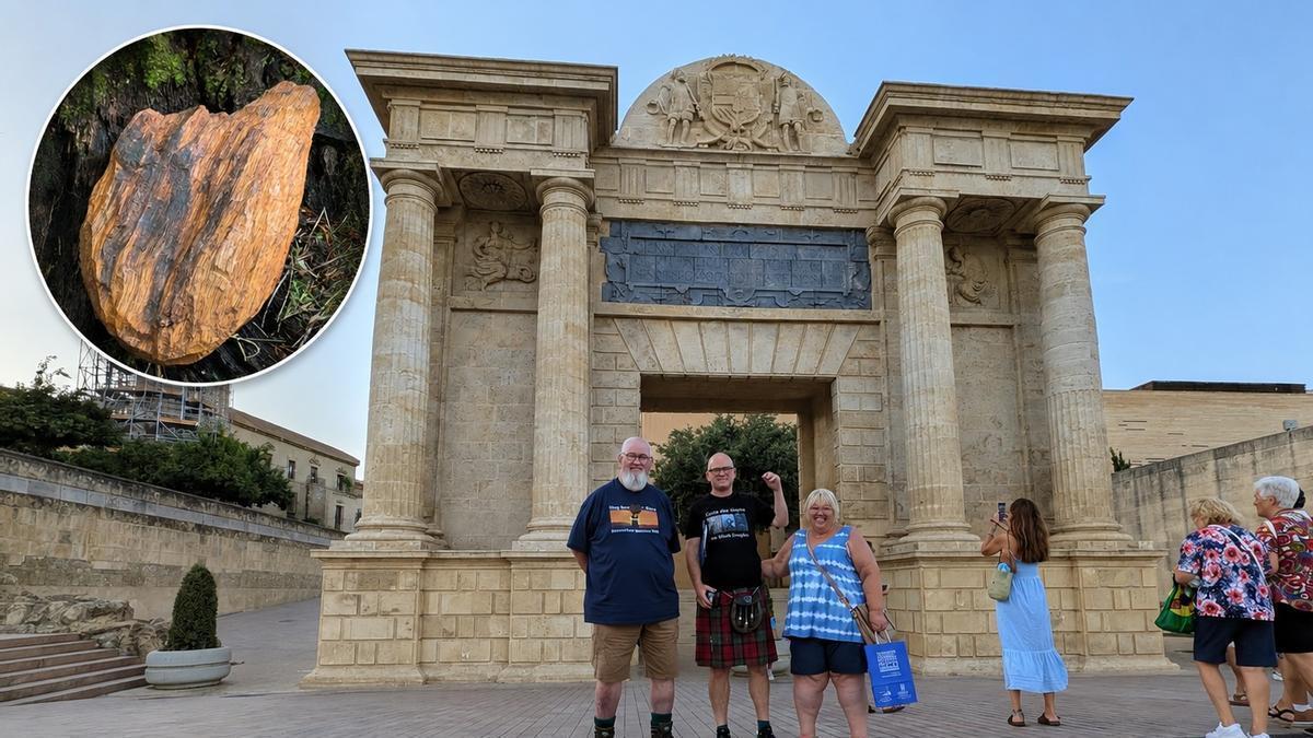 El corazón de madera perteneciente a la asociación escocesa Strathleven Artizans en un círculo, y varios miembros de la asociación ante la Puerta del Puente durante su visita a Córdoba.