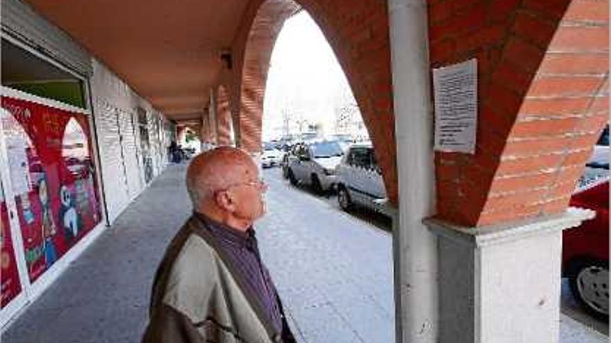 Un veí de Bescanó llegeix un dels fulls que han repartit la població convocant la concentració d&#039;avui.