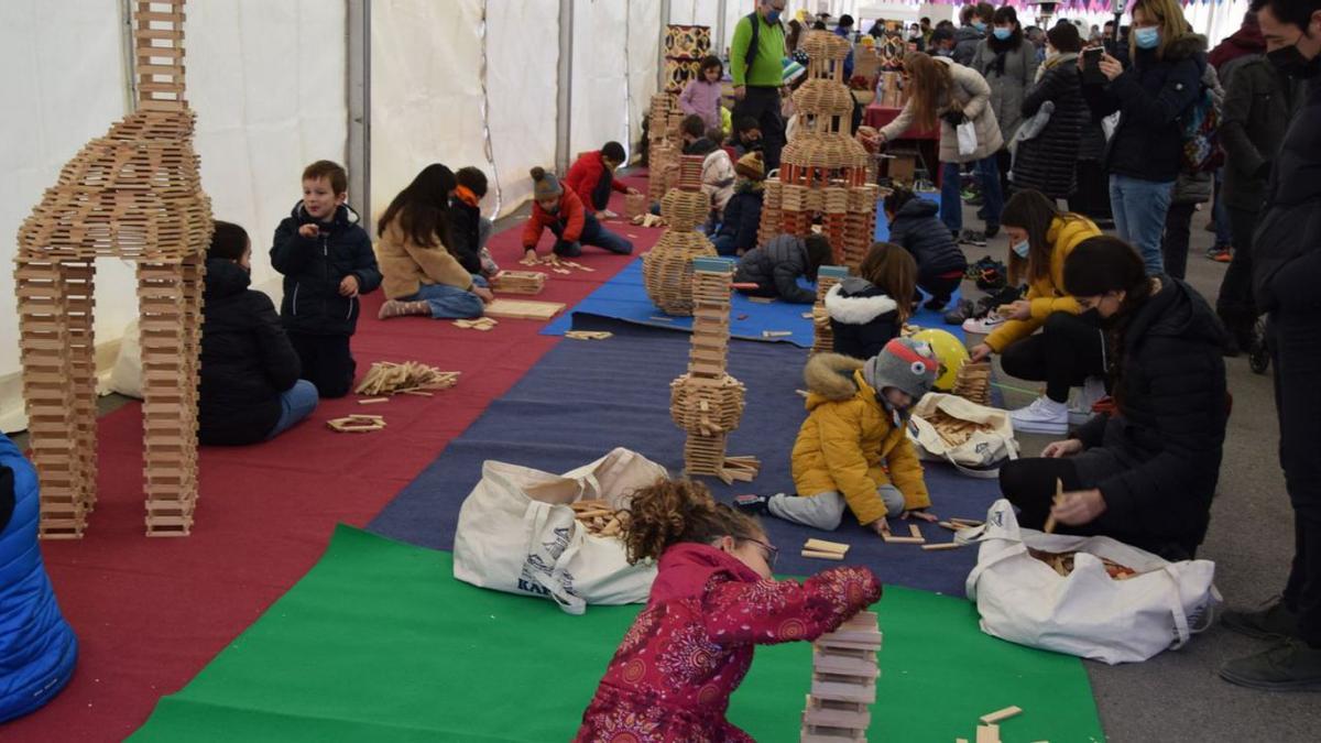 Infants fent construccions amb figures de fusta en una de les carpes de la fira | GUILLEM CAMPS