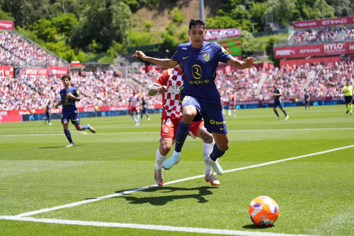 GIRONA, 25/05/2025.- El defensa del Atlético de Madrid, Nahuel Molina (d) con el balón ante el delantero del Girona, Cristian Portugués  durante el partido de Liga que Girona y Atlético de Madrid disputaran este domingo en el estadio municial de Moltilivi. EFE/ Siu Wu