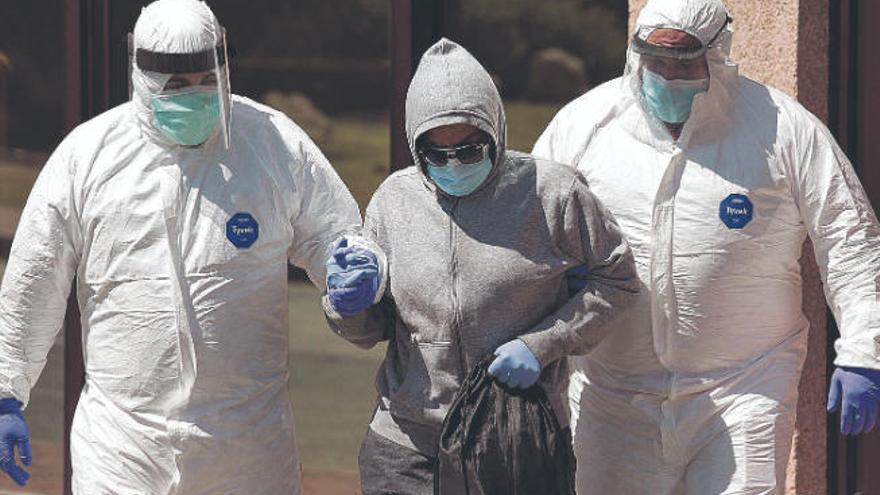 Sanitarios trasladan a una enferma de Covid-19 de un centro de acogida a un hospital.