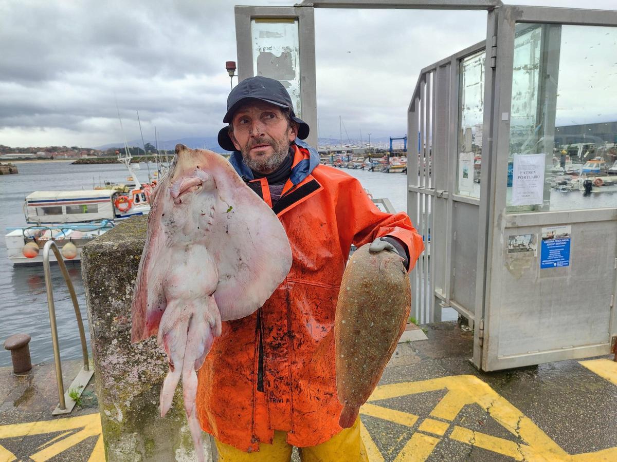 Un marinero de Cangas muestra a principios de enero parte de las capturas del día, una raya y un lenguado.