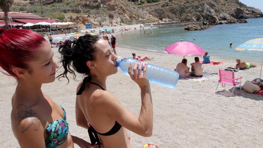 Una joven bebe agua en Playa Cortina (Cartagena)