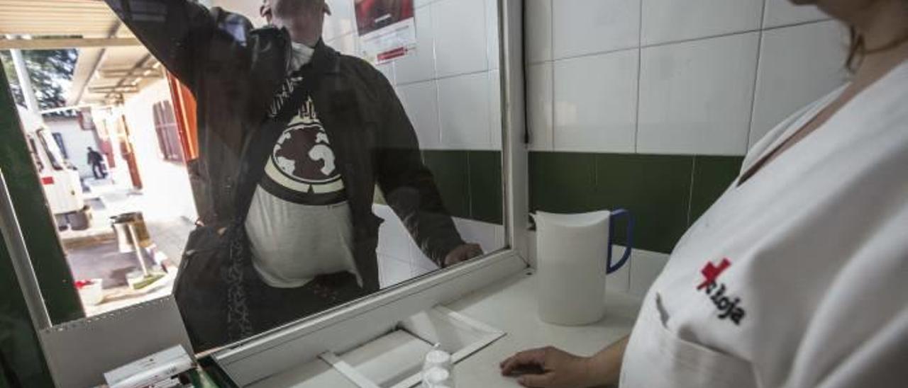 Uno de los pacientes en tratamiento recoge y toma su dosis en el Centro Provincial de Drogas de Cruz Roja.