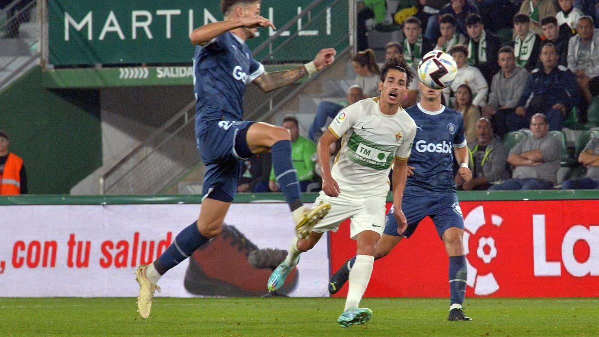 Pere Milla lucha por un balón con un dos jugadores del Girona