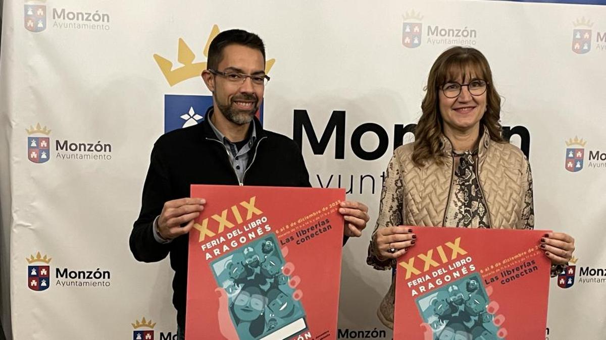 El concejal de ferias del Ayuntamiento de Monzón, Jairo Sánchez, y la directora de la feria, Olga Asensio, con el cartel de esta edición, obra de David Guirao.