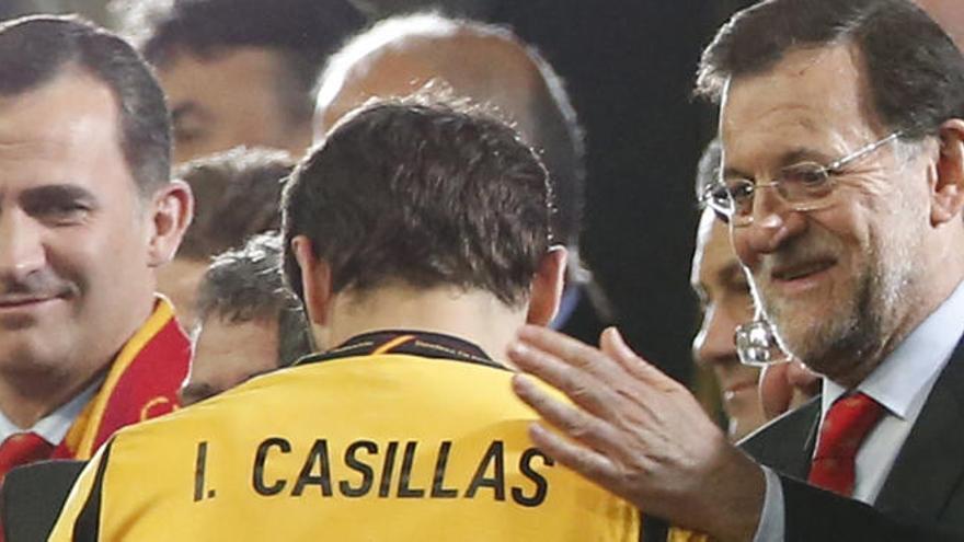 Rajoy felicitando a Casillas con la Selección Española y el Rey al fondo.