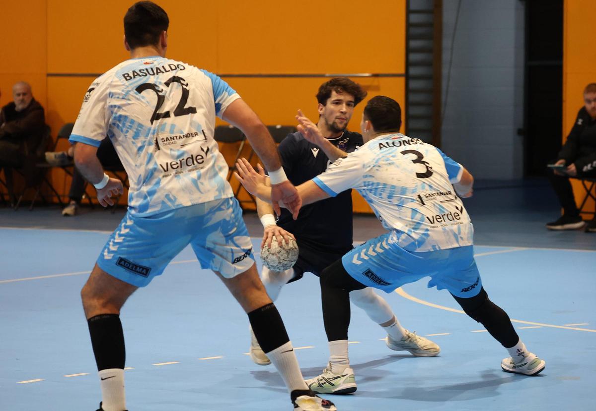 Alberto Roldán encara a dos jugadores del Sinfín en el partido de la primera vuelta.