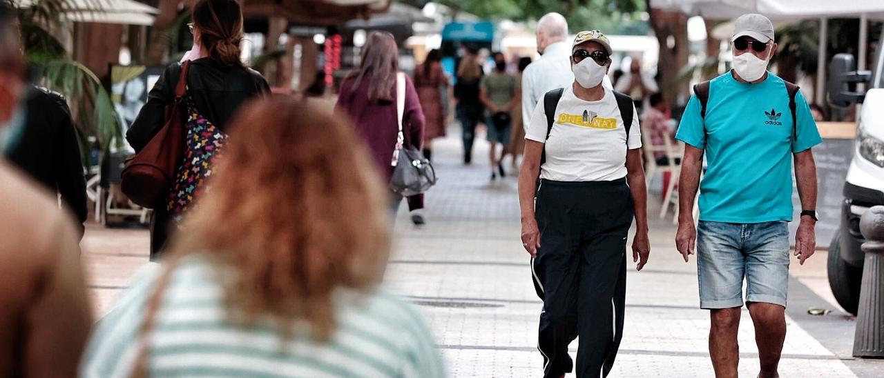 Varias personas con mascarilla caminan por Santa Cruz de Tenerife.