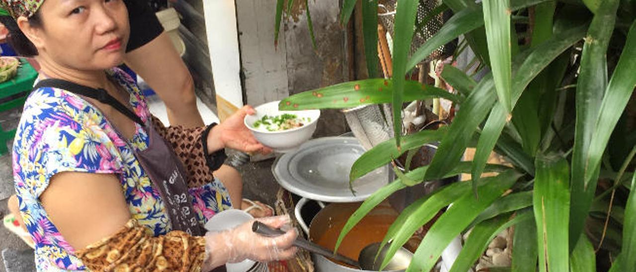 Una cocinera callejera a la puerta del hotel Hanói.