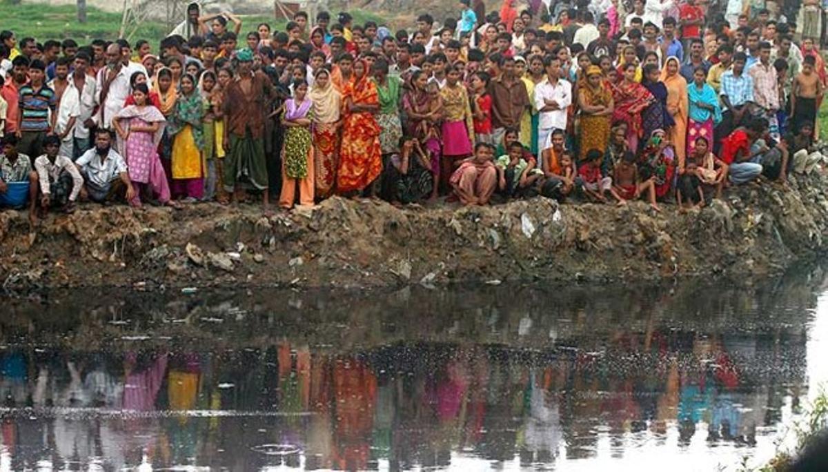 Centenars de bangladeshians observen el rescat dels cossos de 14 persones mortes després de l’enfonsament d’un edifici de 5 plantes sobre una barraca.