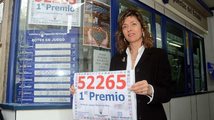La lotera, María del Carmen Cabezudo, muestra el cartel con el premio que entregaron el jueves.  // R. V.