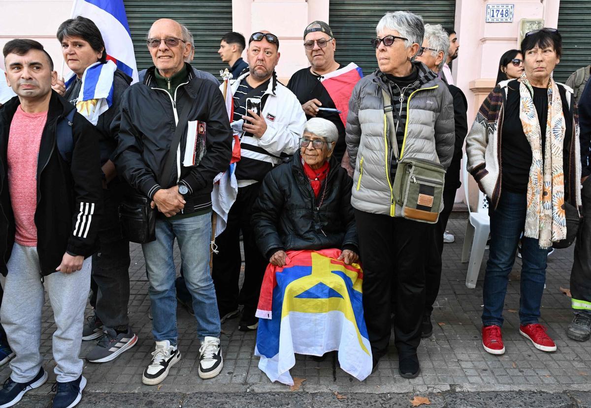 People wait for the passage of the funeral cortege of Uruguays former President Jose Pepe Mujica in downtown Montevideo, on May 14, 2025, a day after his death. Mujica, an ex-guerrilla fighter and hero of the Latin American left, died on May 13, 2025 at the age of 89. The humble leader -- who once spent a dozen years behind bars for revolutionary activity -- lost his battle against cancer after announcing in January the disease had spread and he would stop treatment. (Photo by Eitan ABRAMOVICH / AFP)