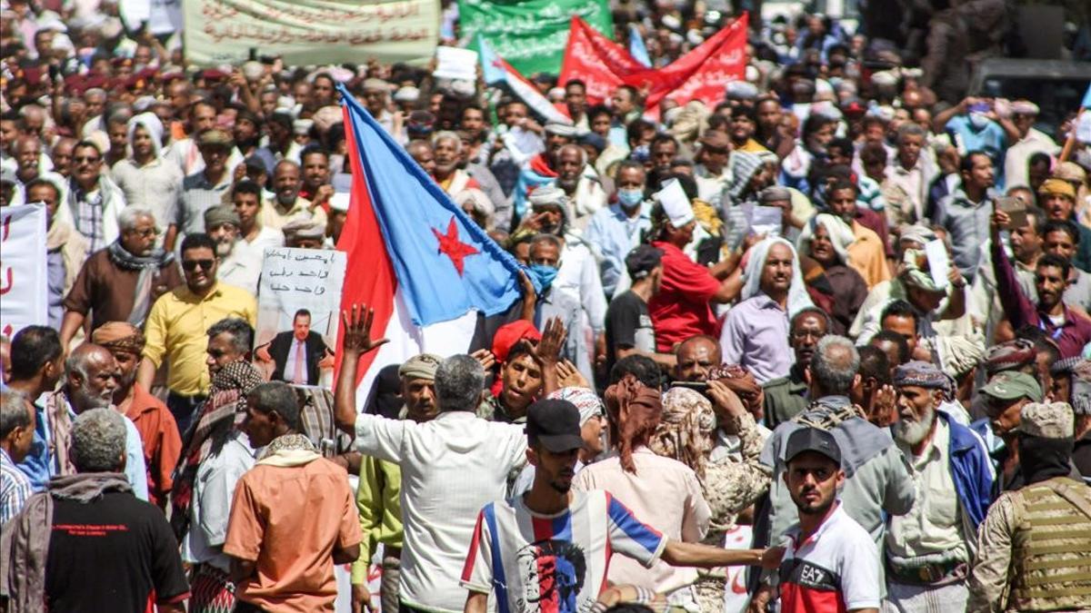 Manifestantes con banderas a las afueras del Palacio Presidencial de Aden.