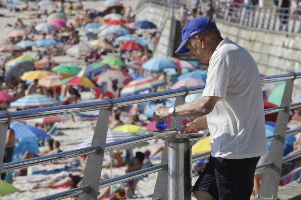 El buen tiempo anima a los bañistas en la playa de Samil