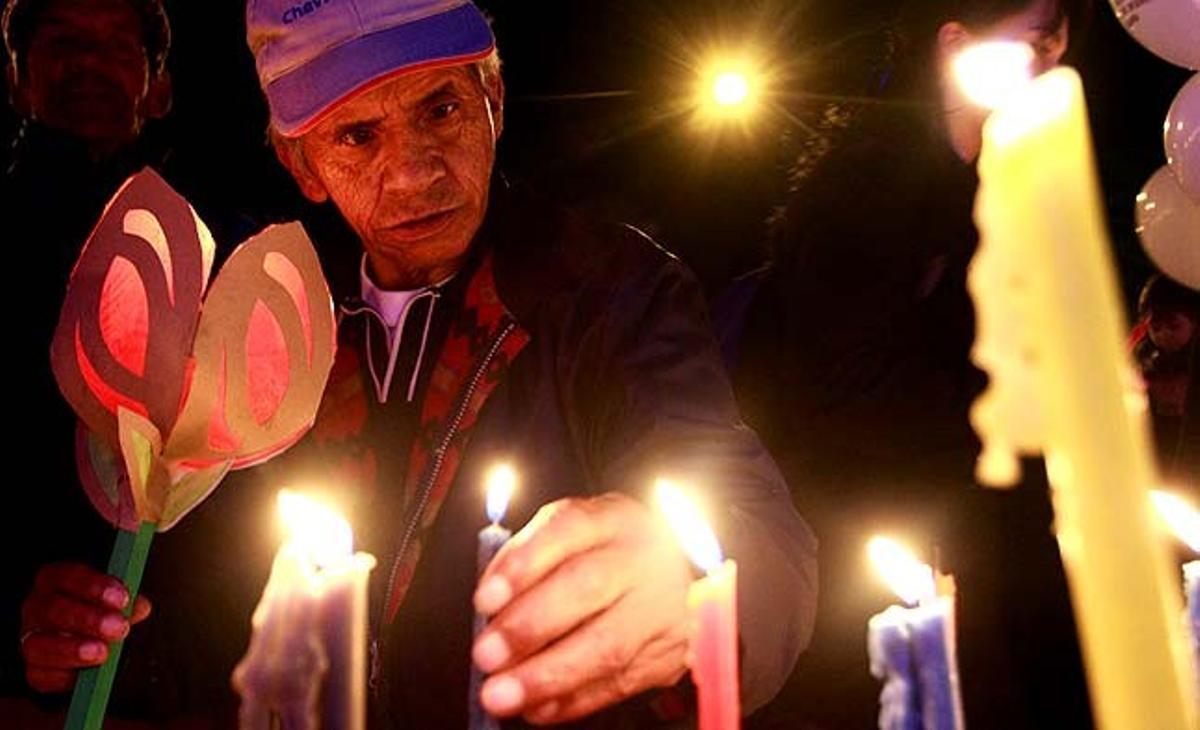 Un home encén espelmes durant la commemoració catòlica del dia de la Immaculada Concepció de la Verge Maria en un parc de Bogotà (Colòmbia).