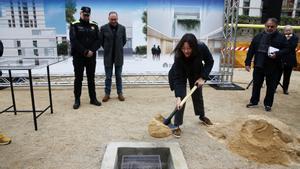 La alcaldesa de Santa Coloma, Núria Parlon, echa una palada de tierra sobre la cápsula del tiempo que ha hecho las veces de primera piedra de la nueva comisaría de la Policía Local