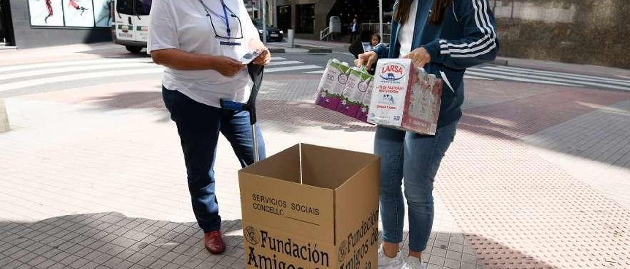 Voluntarias recogen leche para familias en una de las actividades de la organización. // FdV