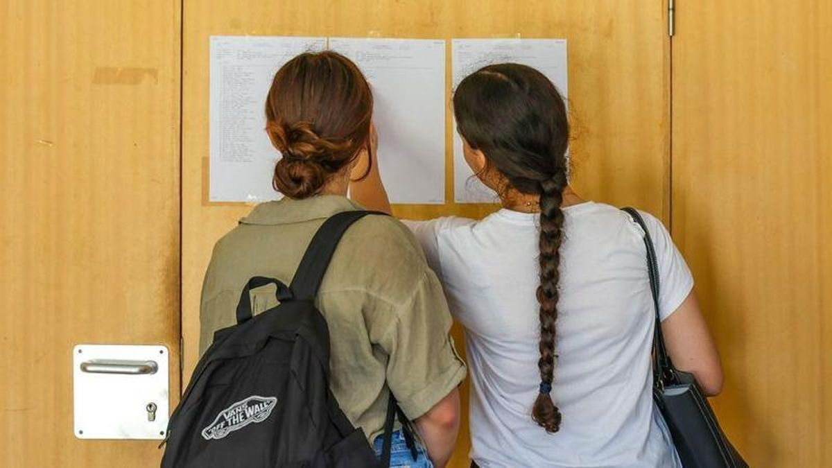 Dos estudiantes consultan las notas de la PAU.