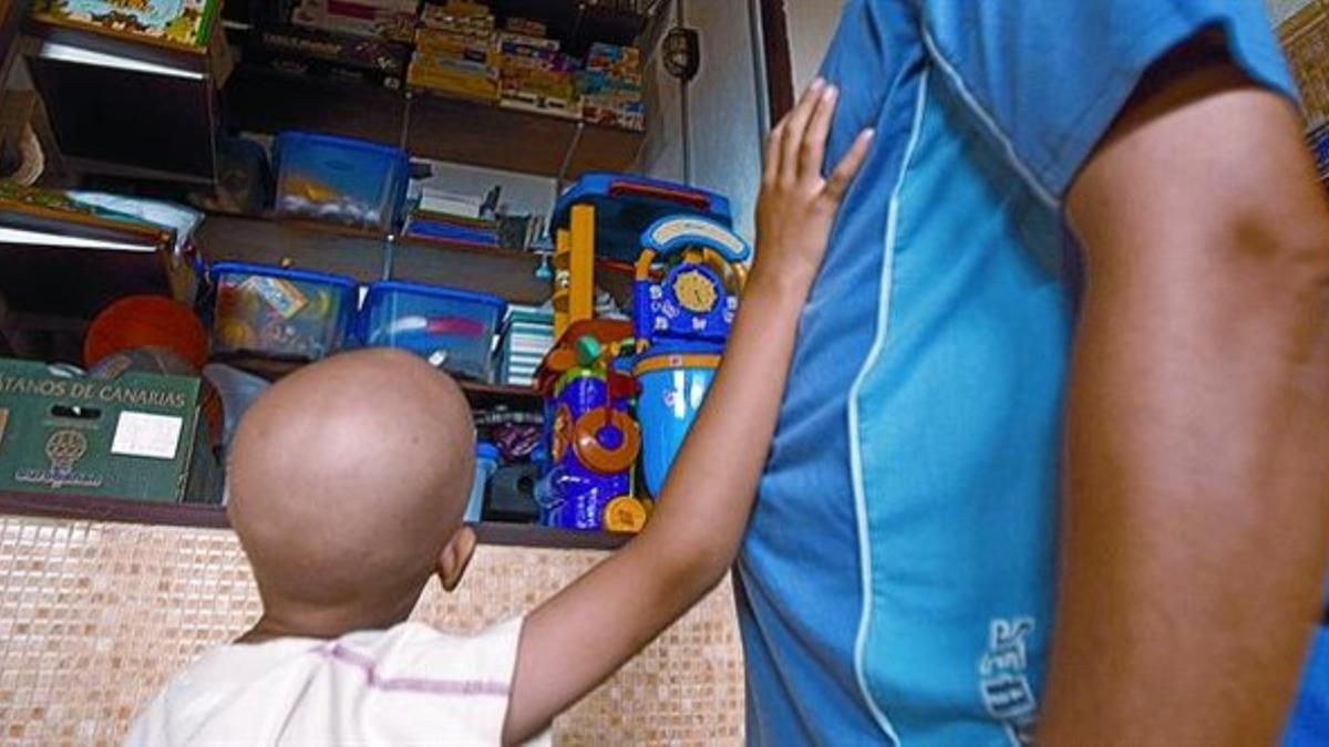 Un niño con cáncer pide un juguete a su padre en un centro de atención oncológica de Tenerife.