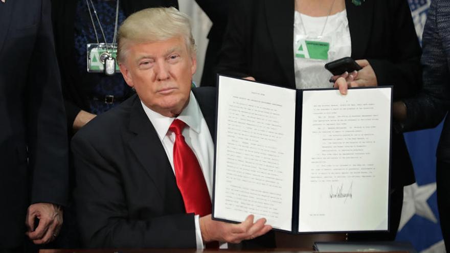 Trump ensenya el document que ha signat avui.