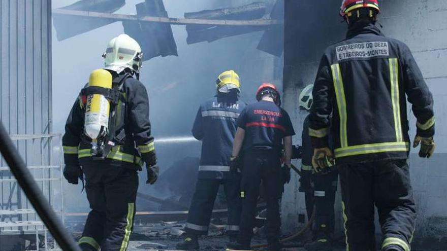 Bomberos durante las labores de extinción del incendio en la nave de Cogal en mayo.