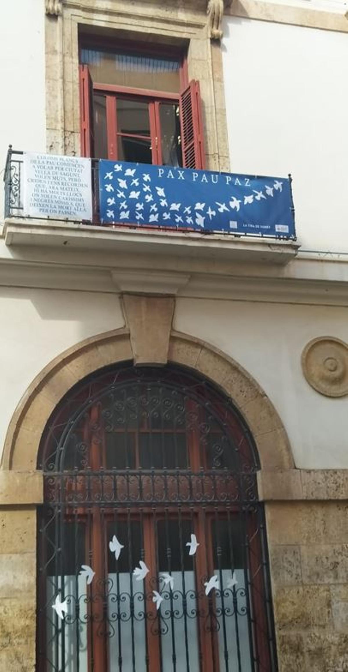 Balcón y ventana del ayuntamiento lleno de palomas blancas.