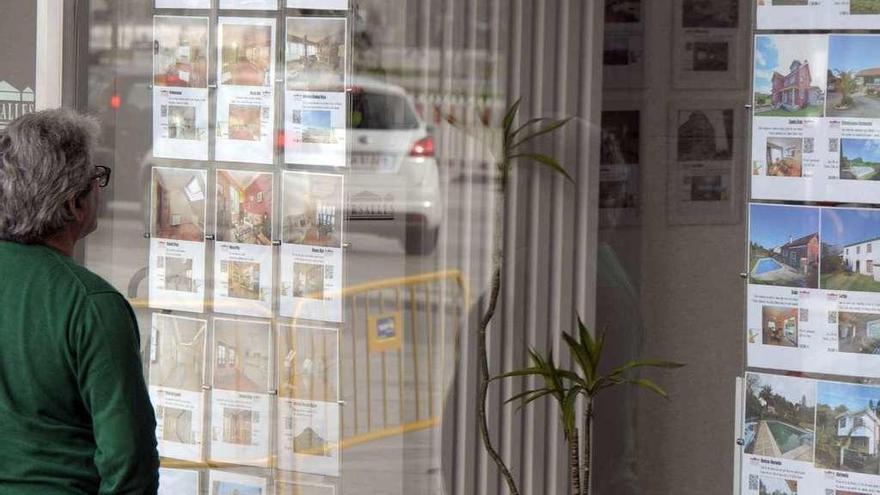 Un hombre observa los carteles de pisos en venta en una inmobiliaria de A Coruña.