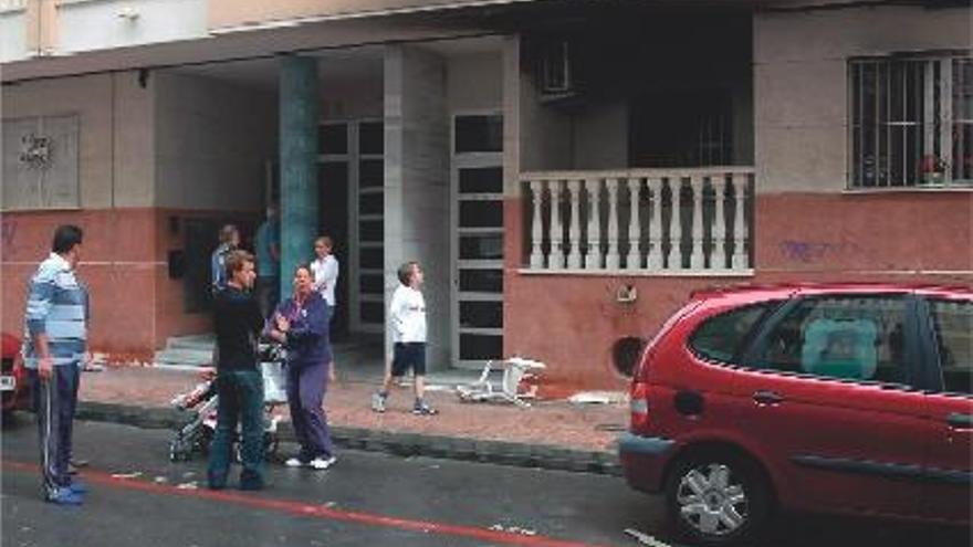 Vecinos frente al inmueble siniestrado ayer por las llamas de un fuego que se originó en una de las viviendas