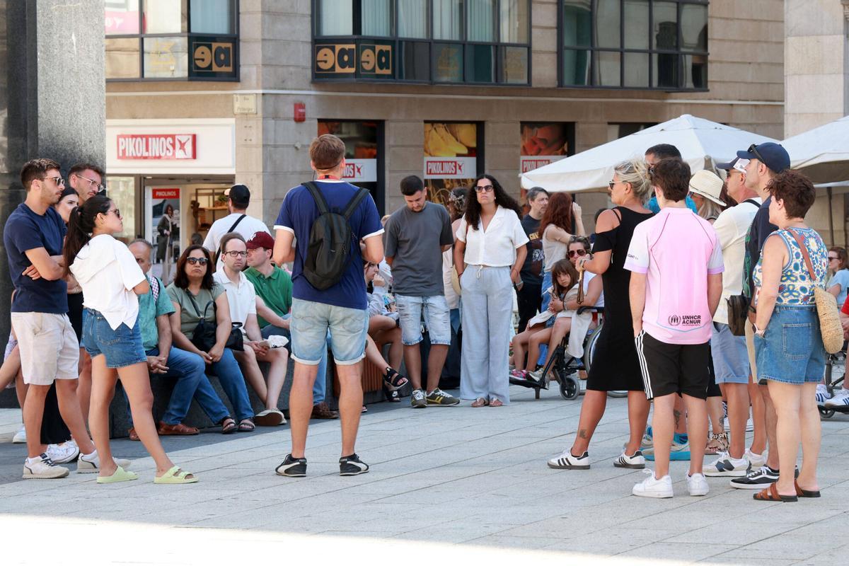 Turistas escuchan las explicaciones de un guía turístico en Vigo.
