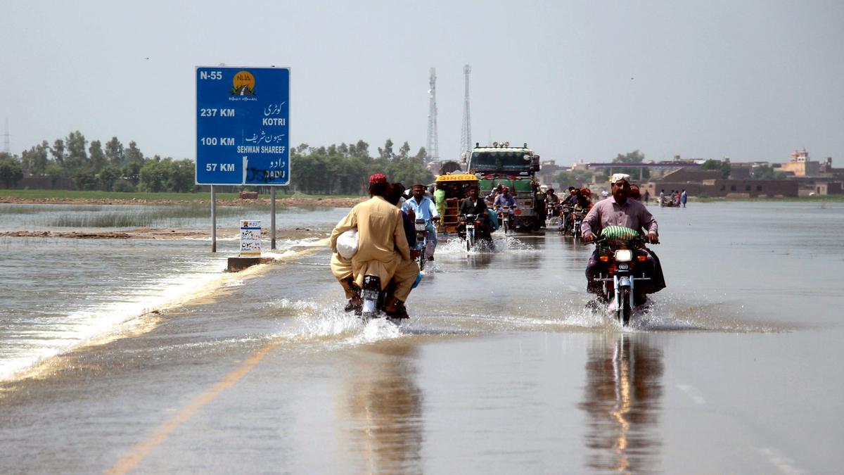 Personas circulando por una carretera inundada en el distrito de Dadu, en Pakistán, el pasado 30 de agosto.