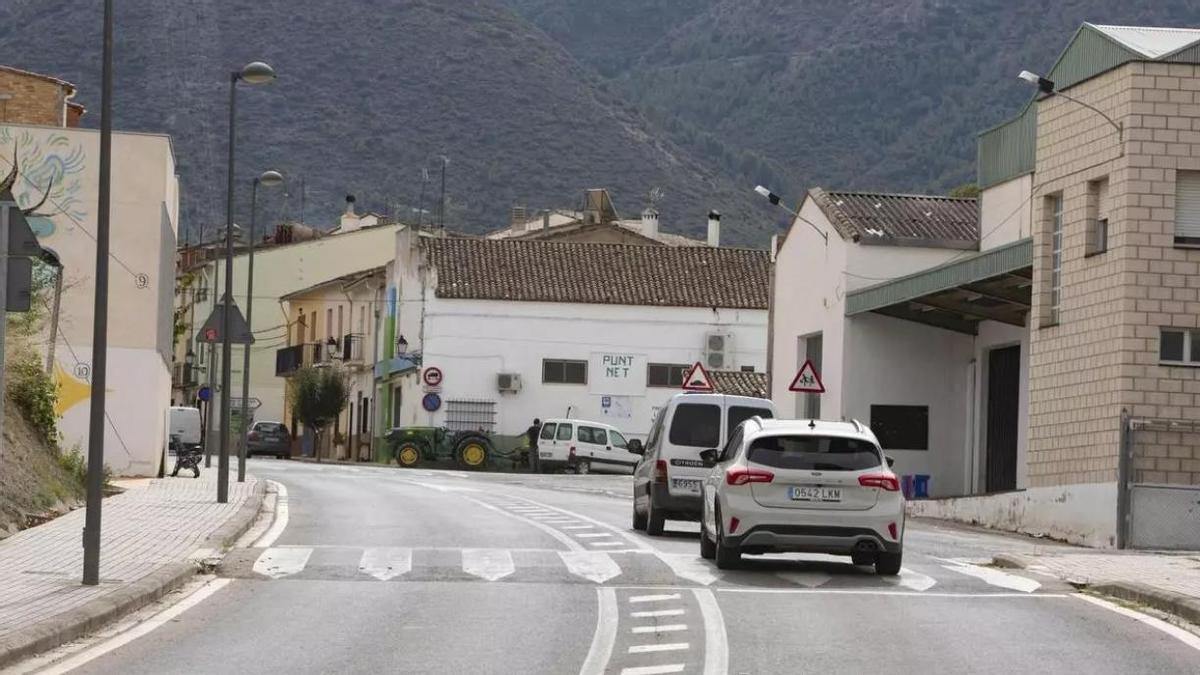 Vehículos circulando por la travesía de Otos en la entrada a la población