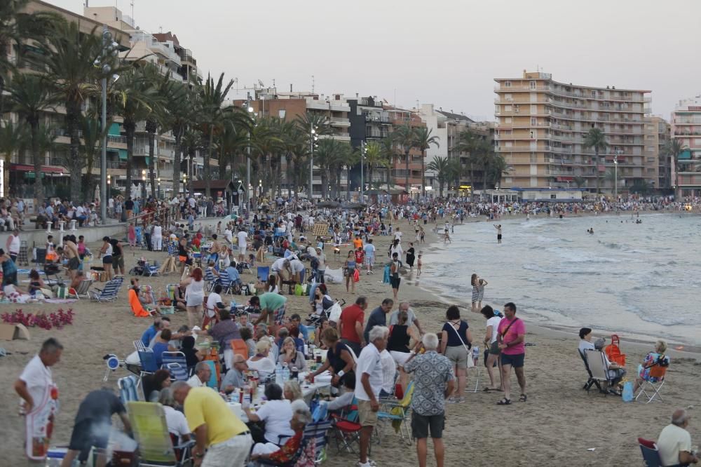 Noche de hogueras, baños, en las playas de la Vega Baja. En las imágenes grupos de amigos y familias en la playa del Cura de Torrevieja